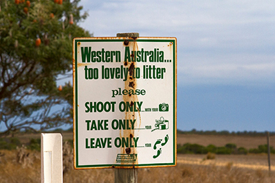 A sign in Western Australia. It reads: 'Western Australia, too lovely to litter. Shoot only with your [camera icon]. Take only your [rubbish icon].Leave only your [footprints icon].' Use these sustainable travel tips to follow these directives.