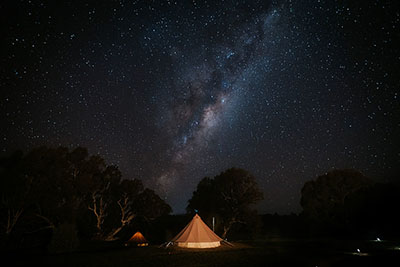 A bell tent sits against the backdrop of a starry night's sky at Mansfield Glamping in Victoria's High Country. This is a great option for anyone searching for eco-friendly accommodation in Victoria.