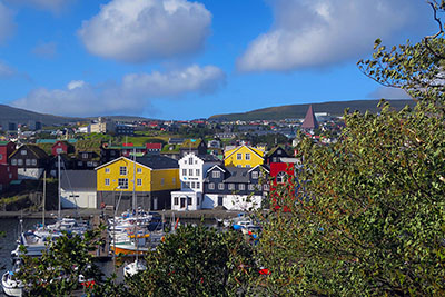 Brightly coloured buildings down the harbour of the Faroe Islands capital. Discover the best things to do in Torshavn.